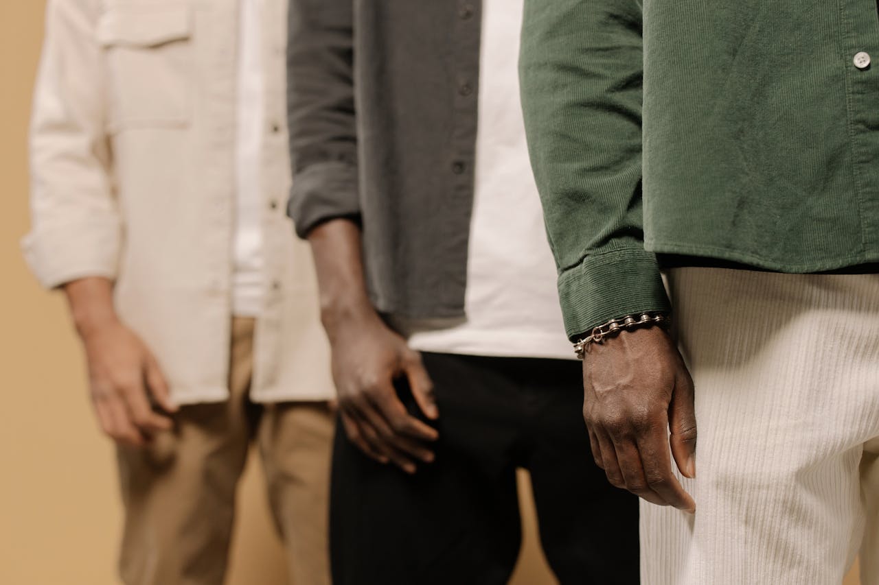 about-us-02 Stylish men's fashion shoot showcasing casual shirts and pants in neutral tones.